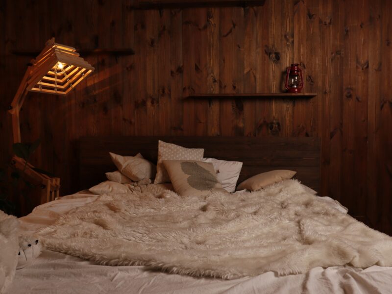 A warm wooden bedroom with a large bed and garden doors
