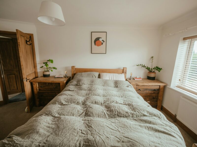 A quiet bedroom with a lamp and open shutters