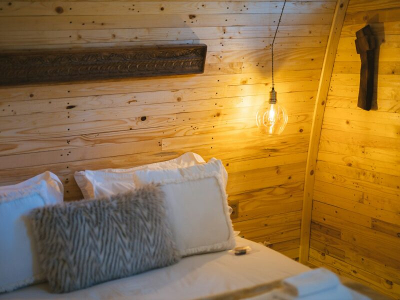 A warm wooden hotel bedroom with soft lighting